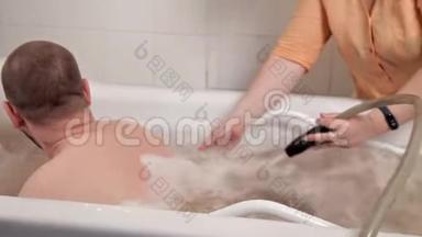 一个男人坐在医用浴油里，一个在水疗中心的女员工，从热水中得到按摩，一种特殊的技术，一种